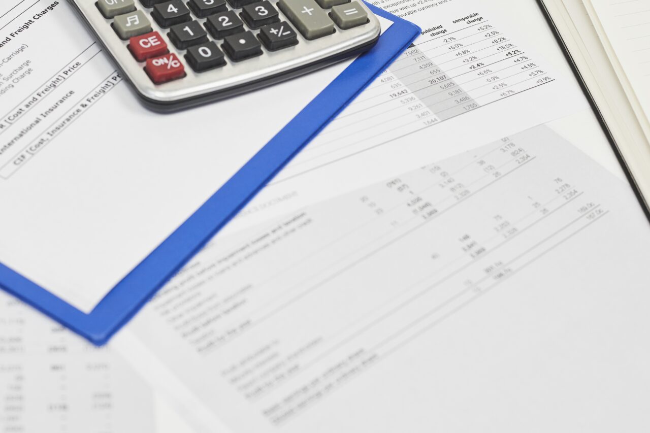 Calculatrice et documents fiscaux sur un bureau, illustrant la déclaration des revenus locatifs meublés au régime micro-BIC en LMNP